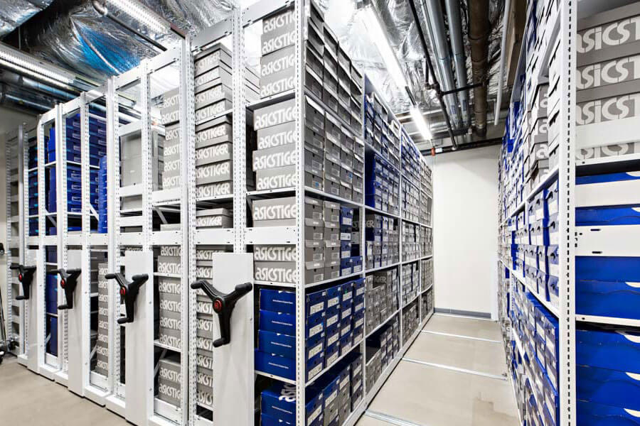 Storage shelving with Asics shoe boxes.