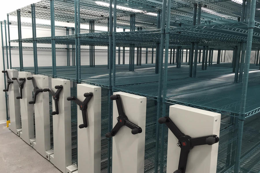 Empty storage racks with movement handles in a warehouse.