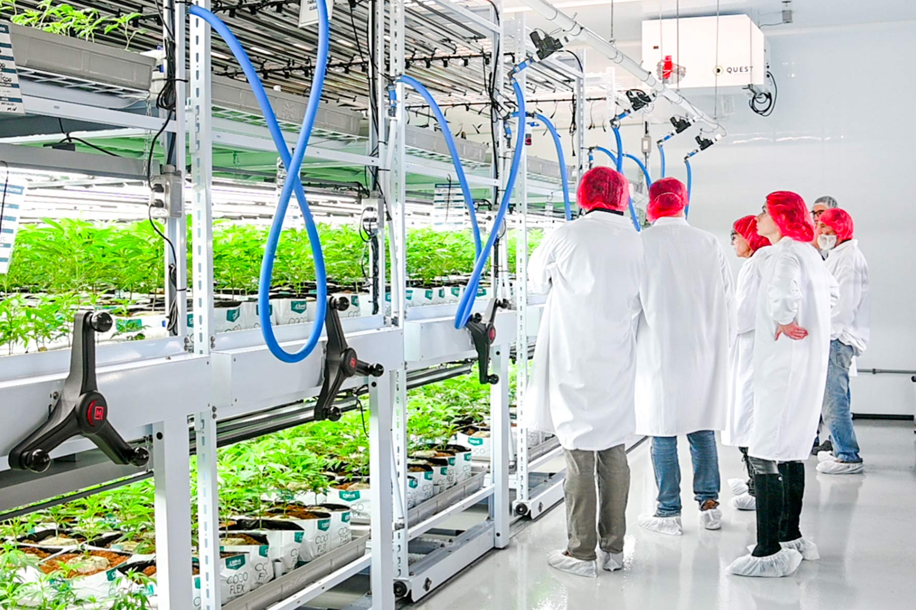 T&#233;cnico inspeccionando un sistema de ventilaci&#243;n en una granja vertical para cultivo de plantas.