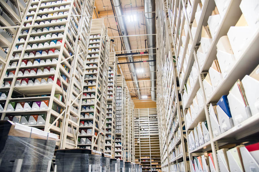 Rows of tall shelves filled with documents and archive boxes.