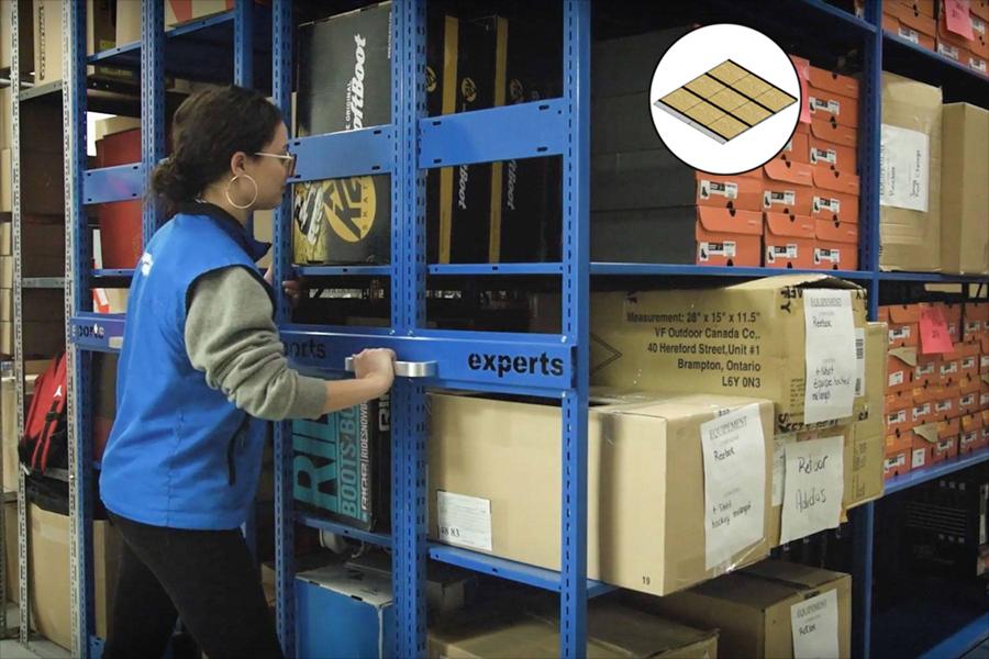 Employee using a blue Montel mobile shelving system for storing items and boxes.