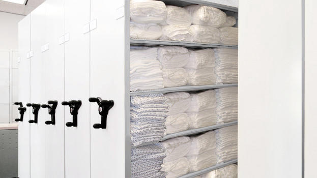 Compact shelving for folded linen storage in healthcare settings.