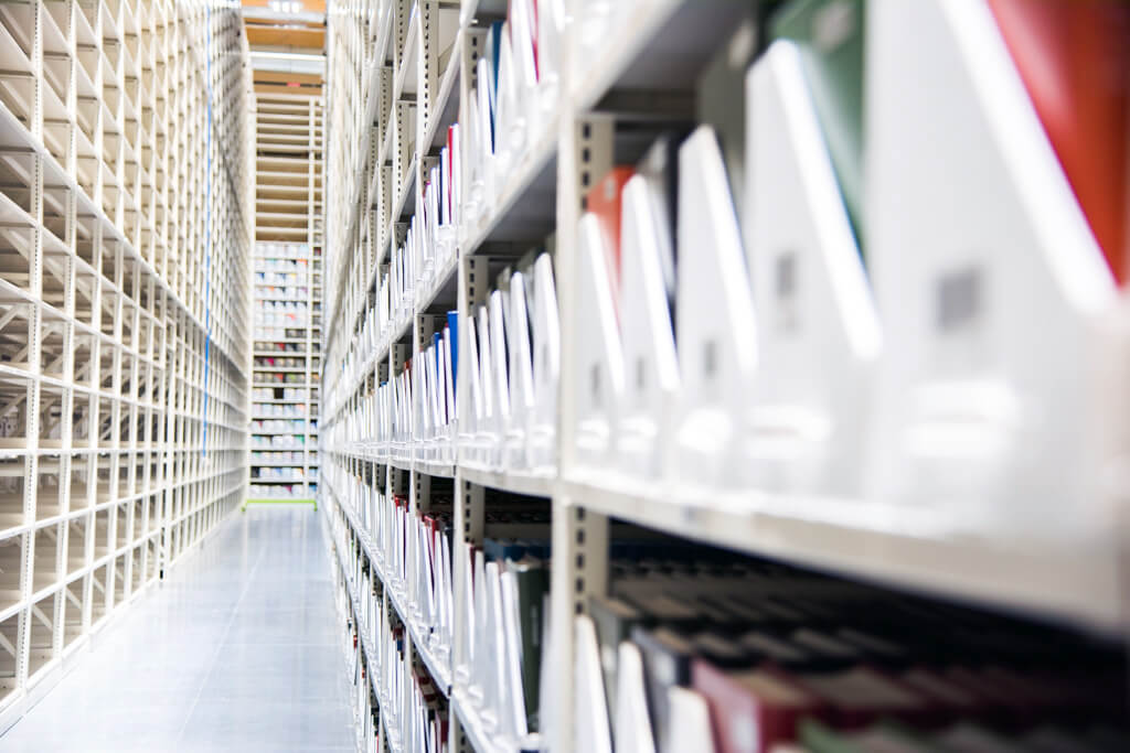 White shelves filled with documents, illustrating an organized storage environment.