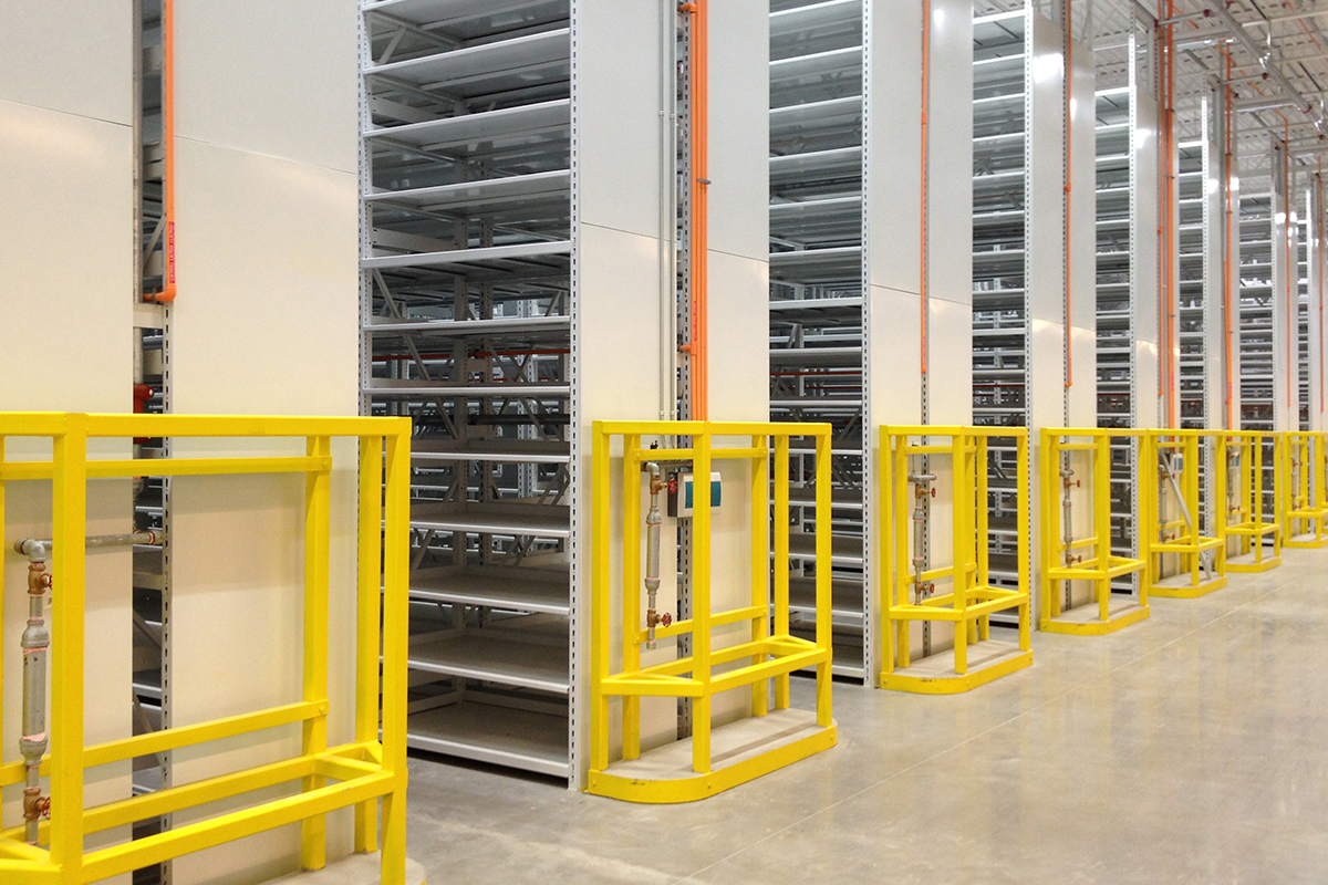 Mobile shelving system with yellow safety barriers, ensuring safe and accessible storage.