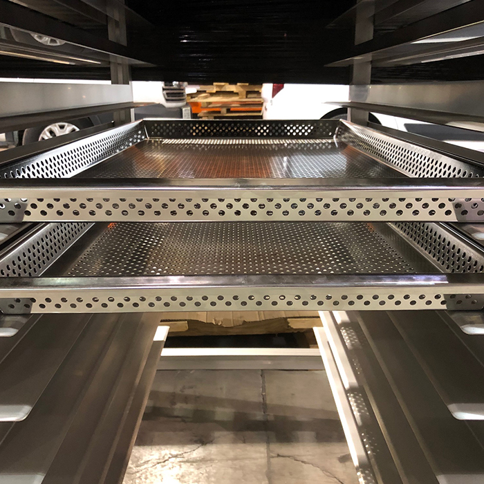 Close-up of a perforated metal shelf, used in an industrial storage system.