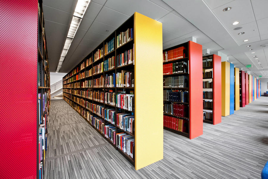 Salle d&#39;&#233;tude dans une biblioth&#232;que avec si&#232;ges verts et &#233;tag&#232;res remplies de livres.