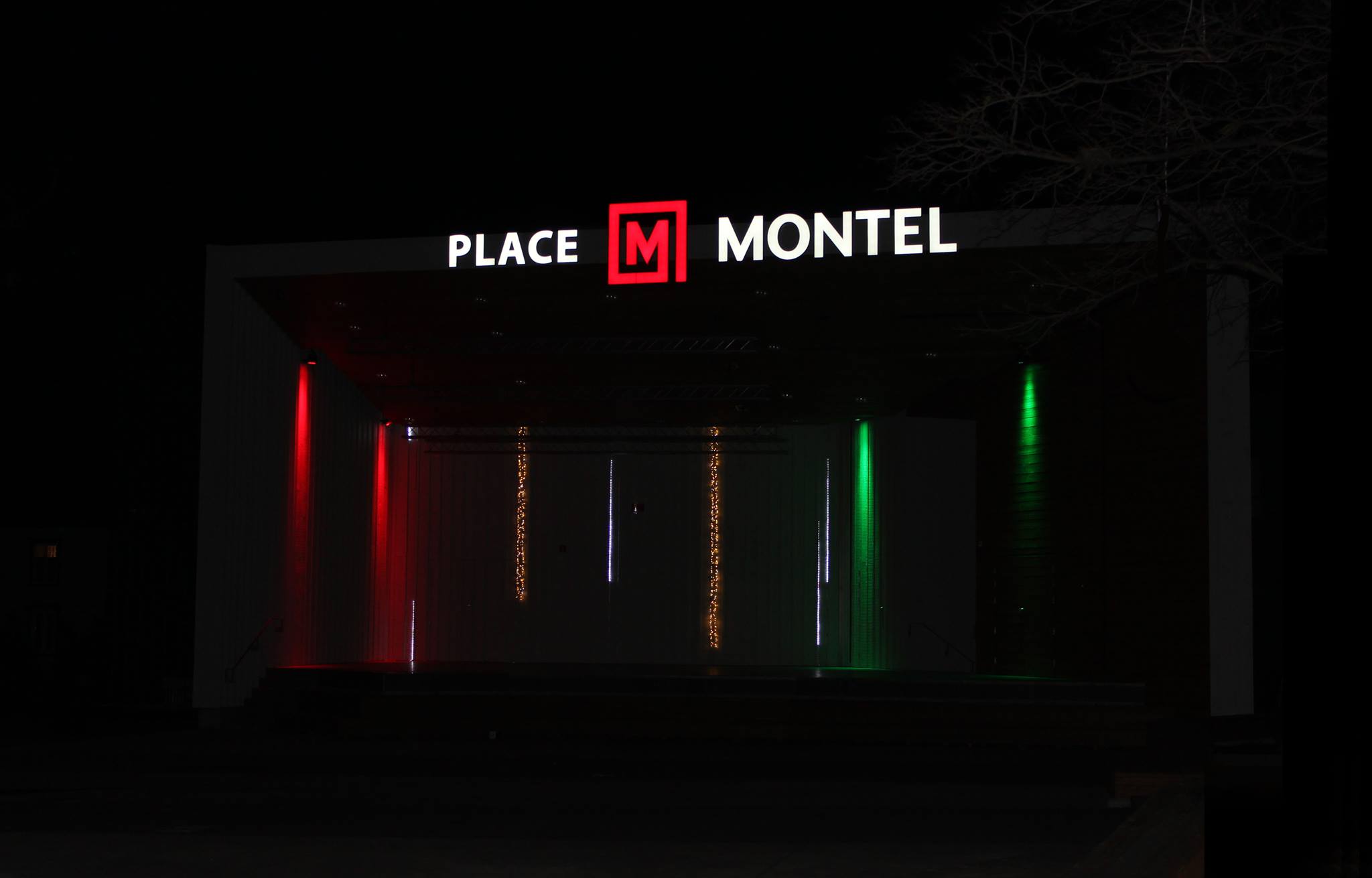 Illuminated entrance of Place Montel at night.