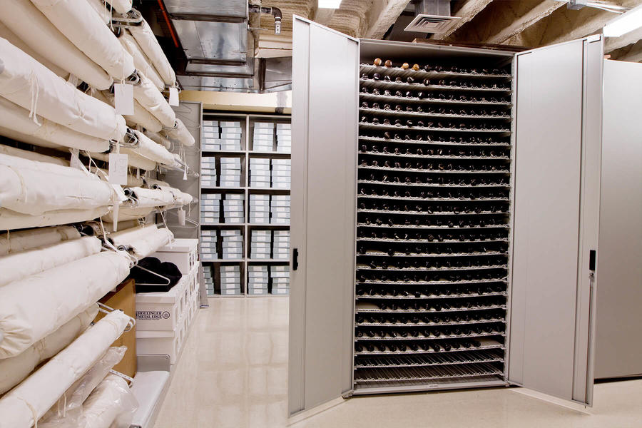 Storage cabinet with preserved material rolls, organized compartments, and closed covers.