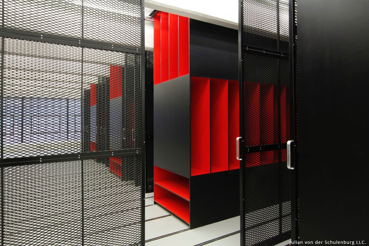 View of a storage corridor with black and red shelving, creating an organized art environment.