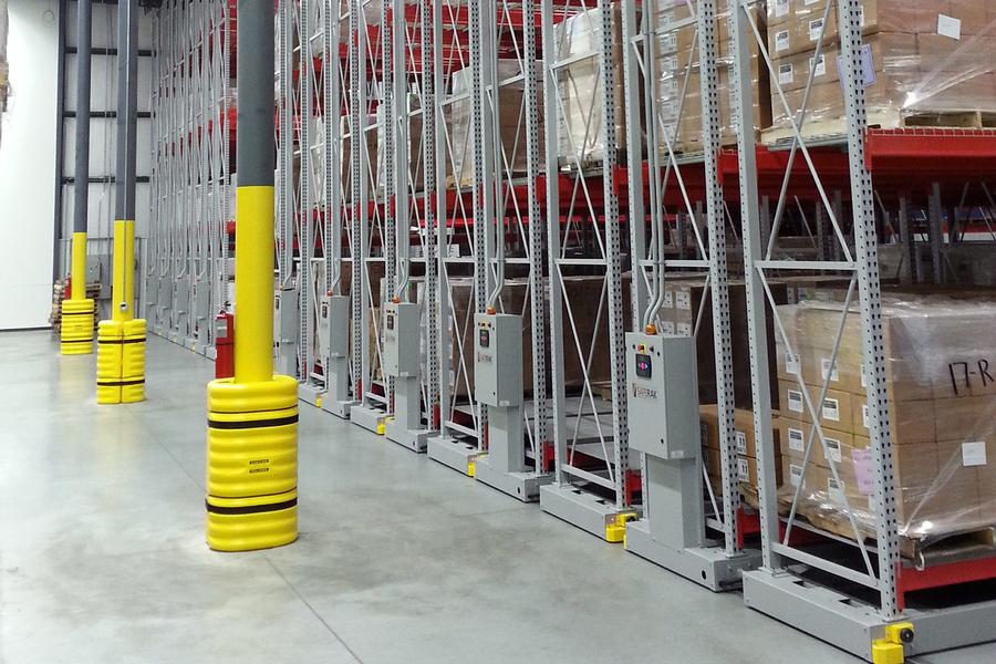 Industrial storage racks with yellow protection in a warehouse.