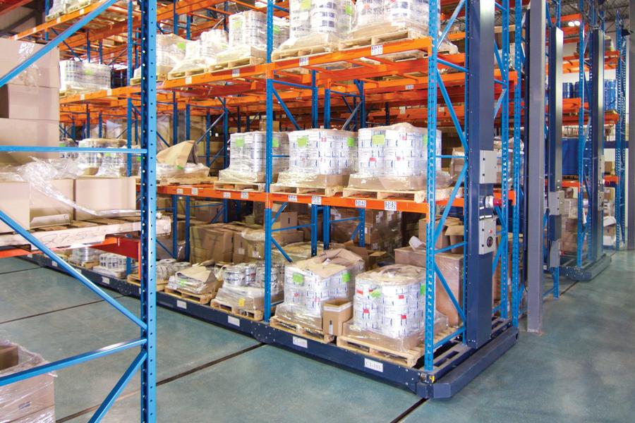 Shelving system in an industrial warehouse, loaded with material pallets.