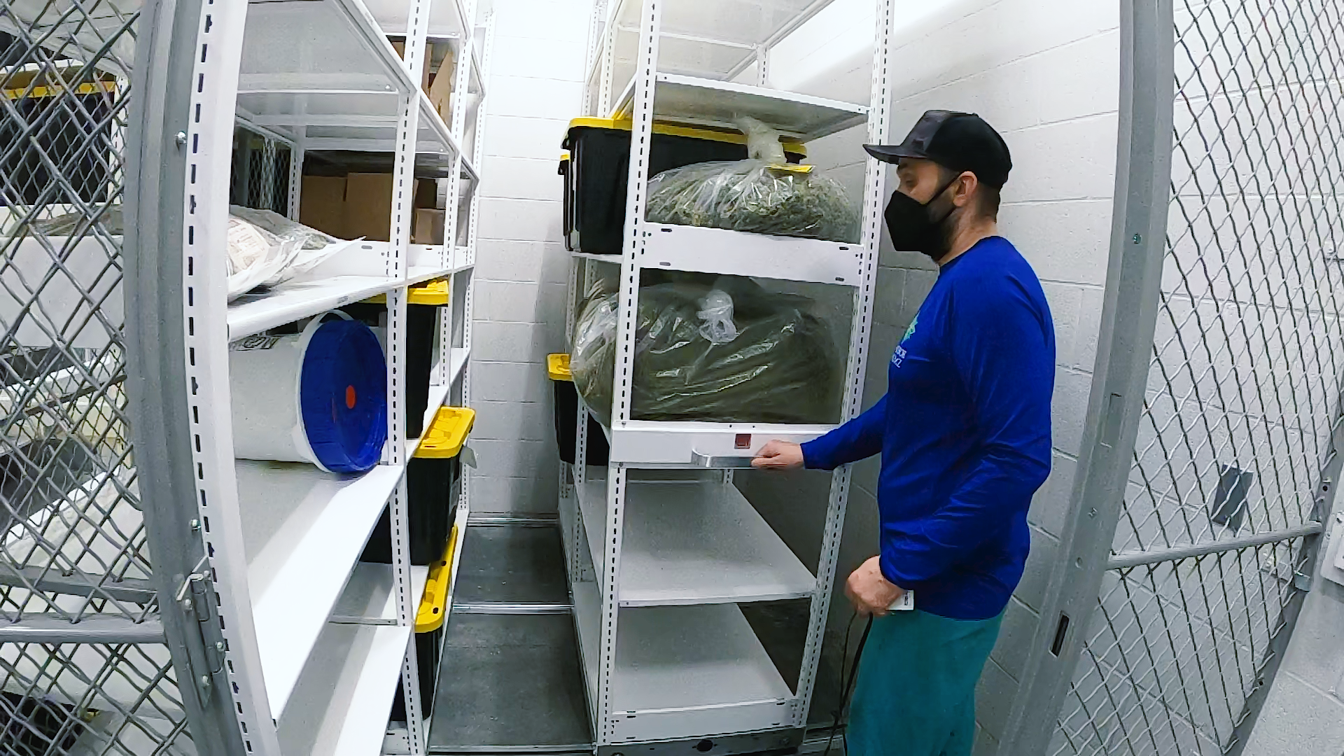 Employee using a blue Montel mobile shelving system for storing items and boxes.