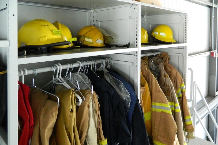 Casiers de stockage avec casques et vestes de protection pour les pompiers.