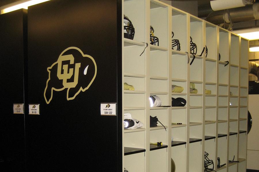 Football helmets and equipment stored in CU university shelving.