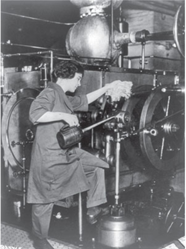 Femme travaillant sur une machine industrielle, nettoyant et lubrifiant les pi&#232;ces dans une usine.