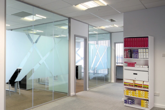 Modern office space with glass partitions in an open workspace.