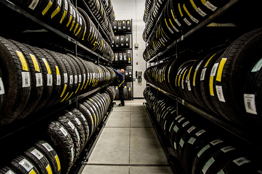 Aisle of tires stored on Montel mobile shelving, optimizing warehouse storage space.