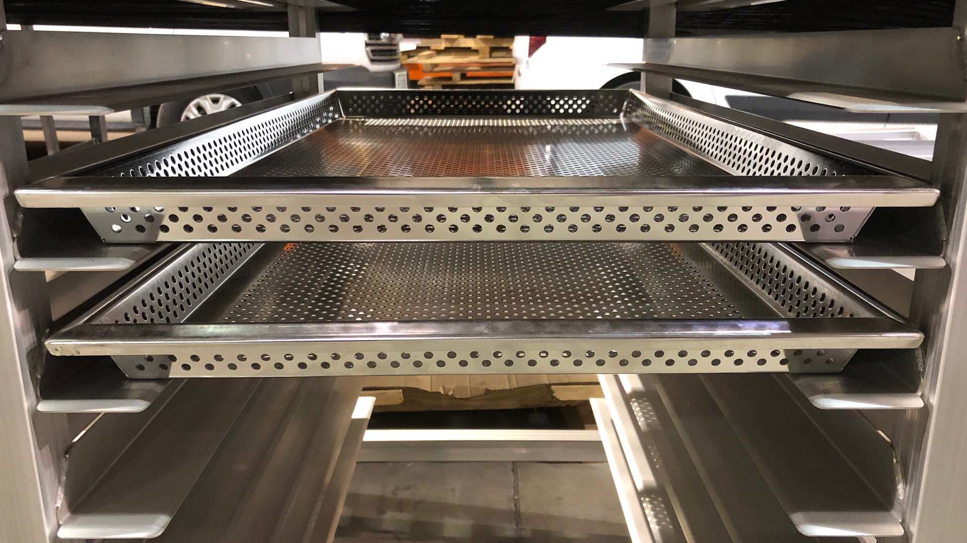 Close-up of a perforated metal shelf, used in an industrial storage system.